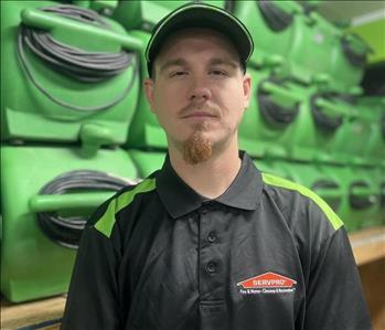 servpro employee in a black polo against a green background